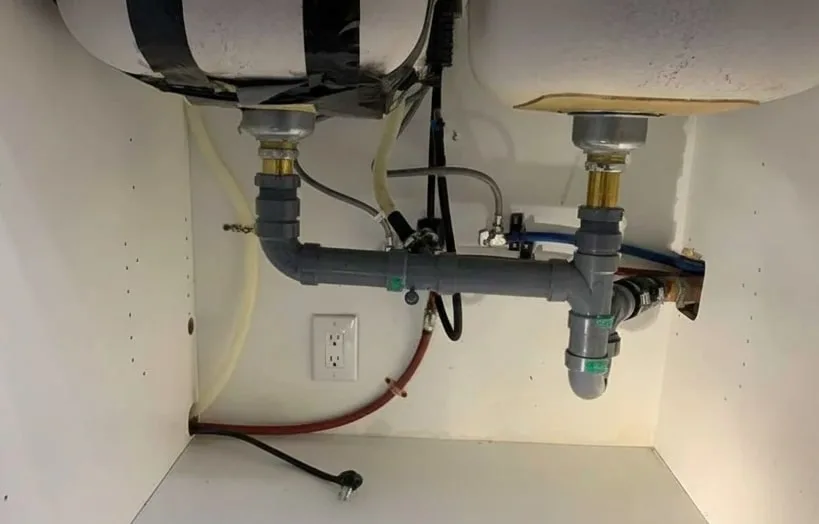 New PVC pipes installed under a double sink